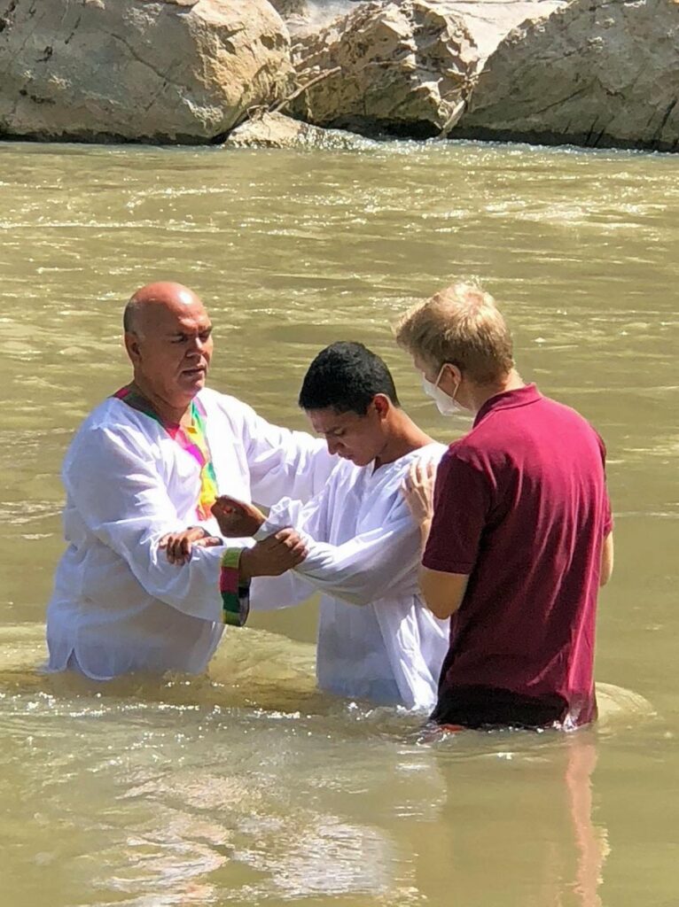 Three men standing in river