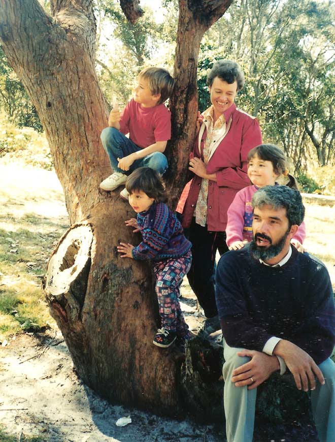 Burgess family pose around a partially cut-down tree