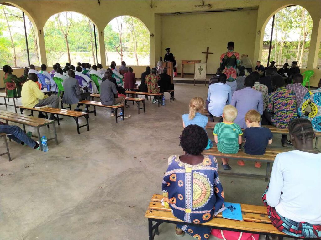 interior of church in rural Ethiopia, three small white children visible among black congregation