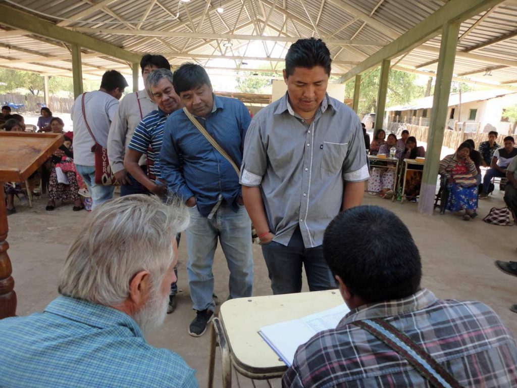 leaders register for training in an open building with corrugated roof