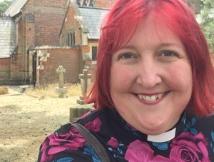 Rachel Noël in clergy collar with shocking pink hair