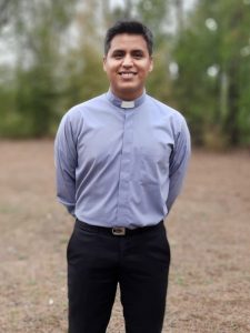 Smiling Latino man in clerical shirt