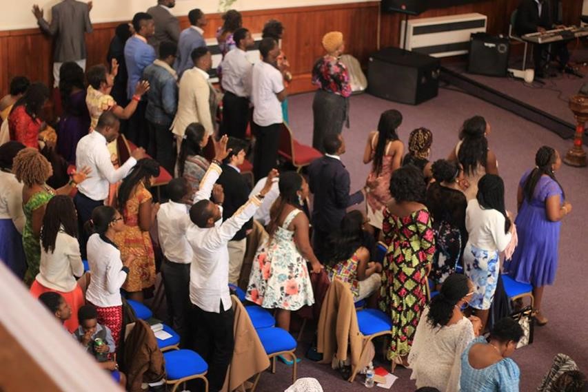 Black congregation with raised hands seen from abiove