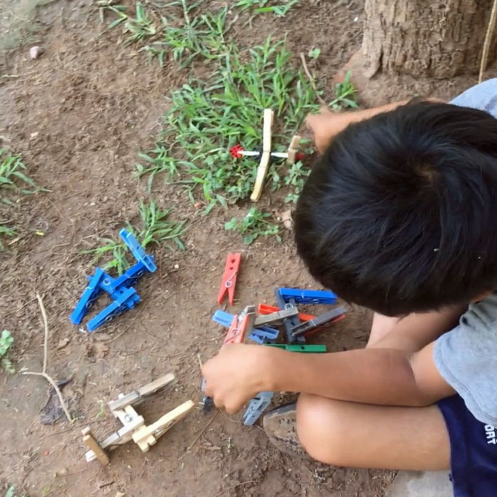 boy  plays with models made of clothes pegs