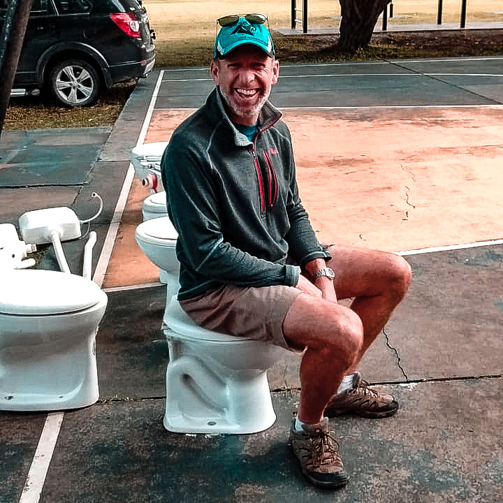 Mission partner Andrew Peart sits on a recently purchased toilet basin before loading it for transportation