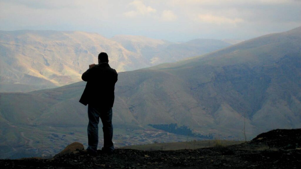 lone man silhouetted against Middle Eastern hills