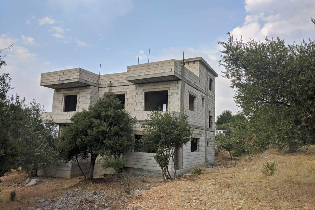 two-storey shell of a house built from breeze blocks