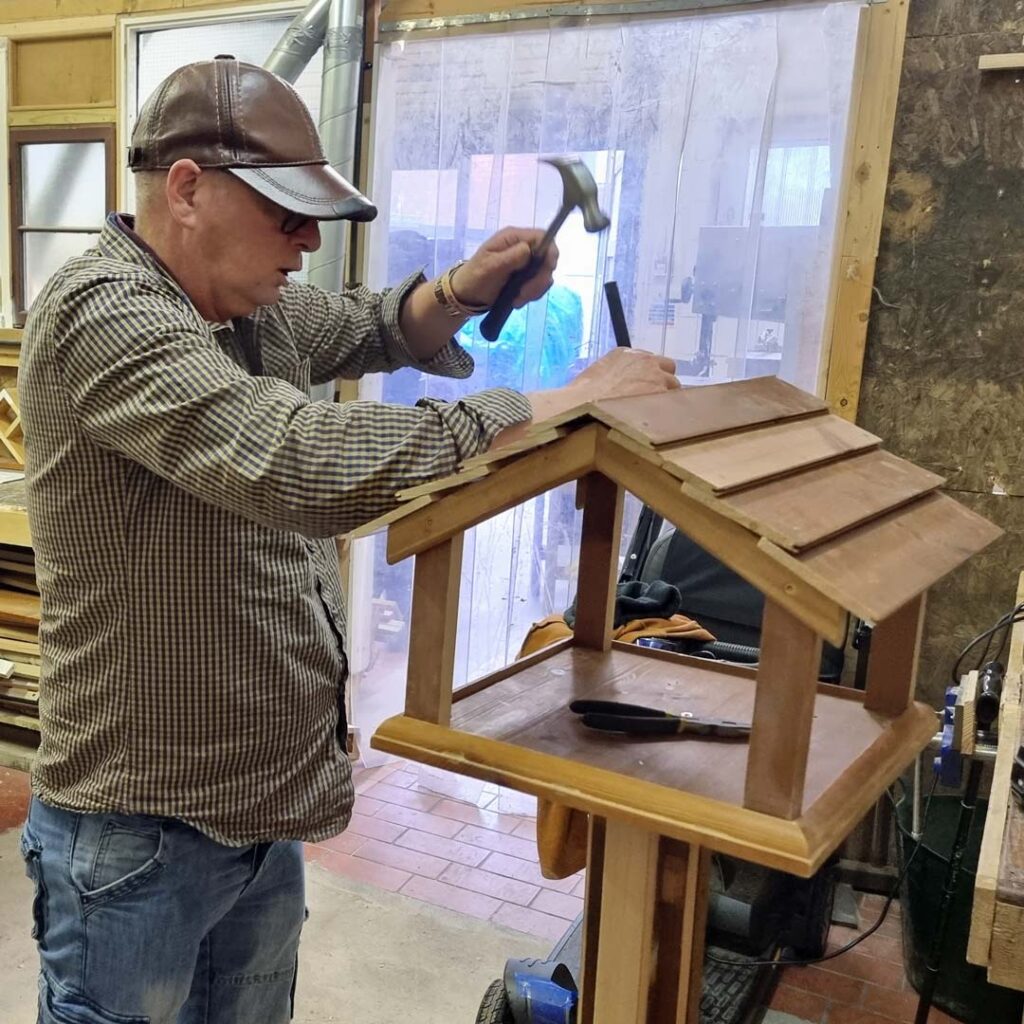 A Community Shed member puts the final touches to a bird table