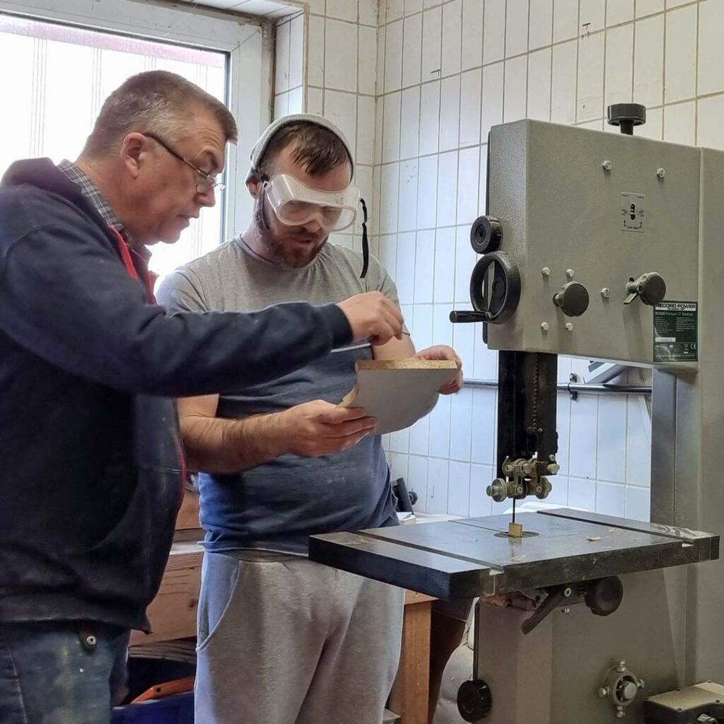 Garry advises a shed member at a woodworking machine