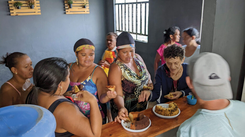 women from the local community tuck into cake