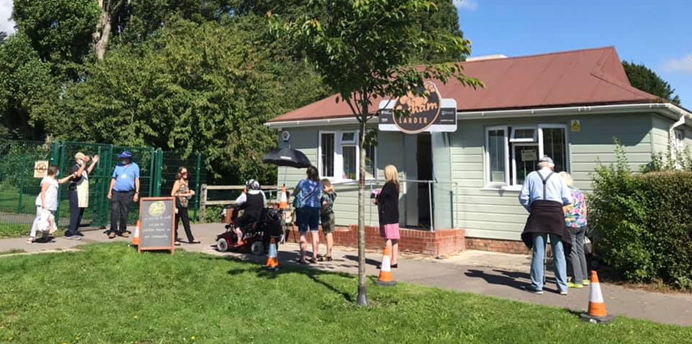 small pavilion in a park with community members outside