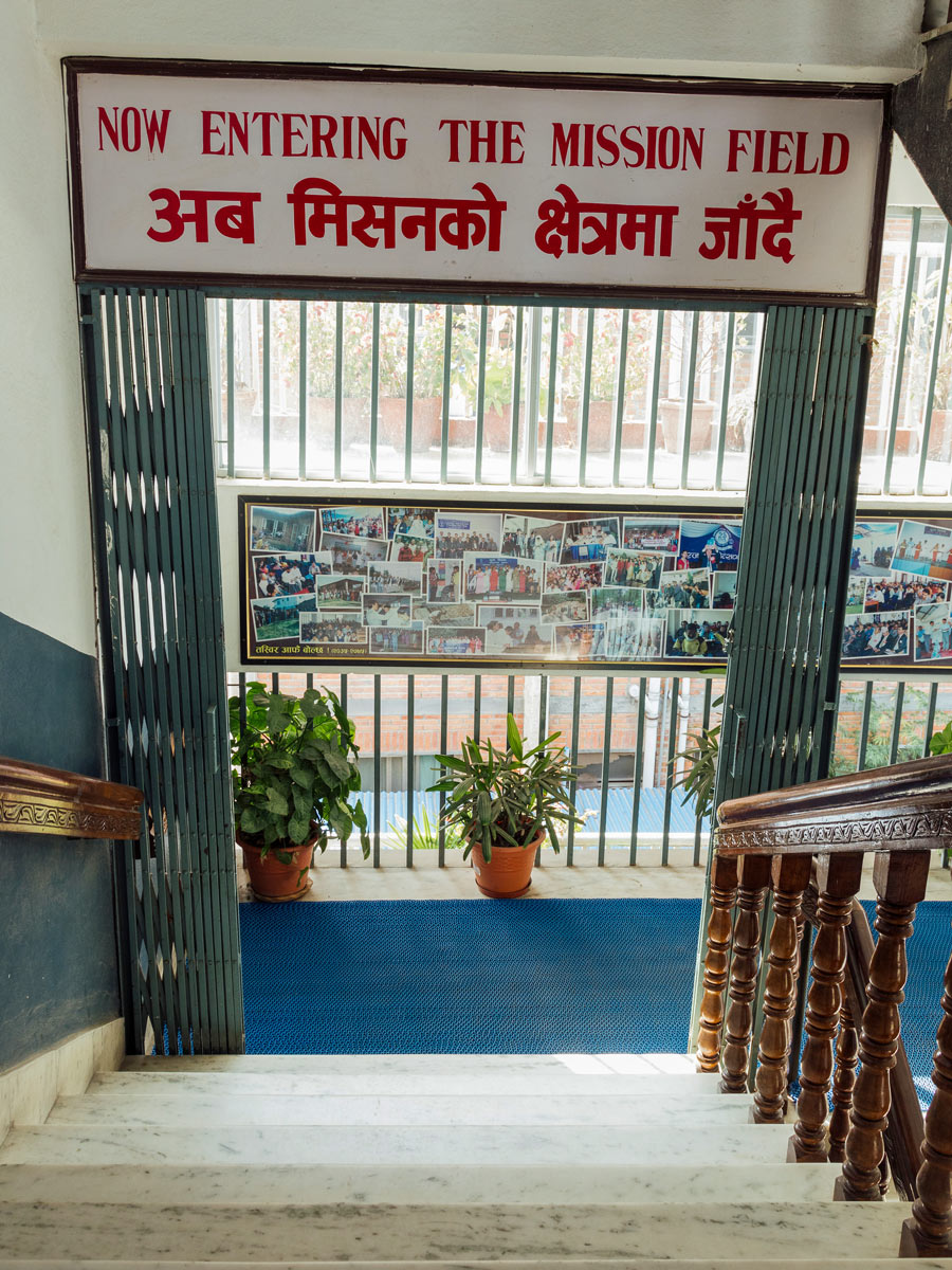 Sign above stairs on leaving church: "Now entering the mission field" (In Nepali and English)