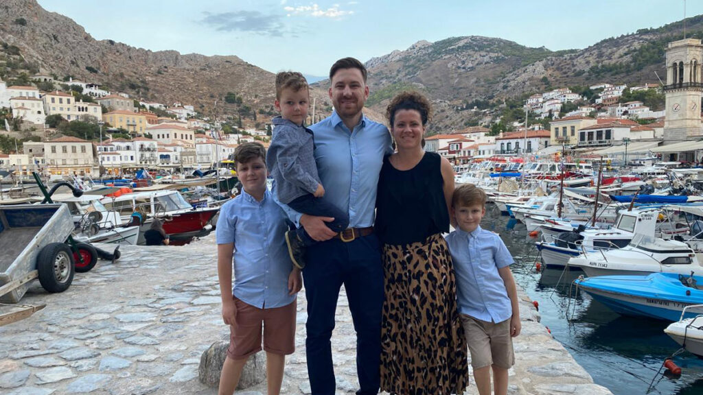 Marcus and his young family on a Greek harbourside