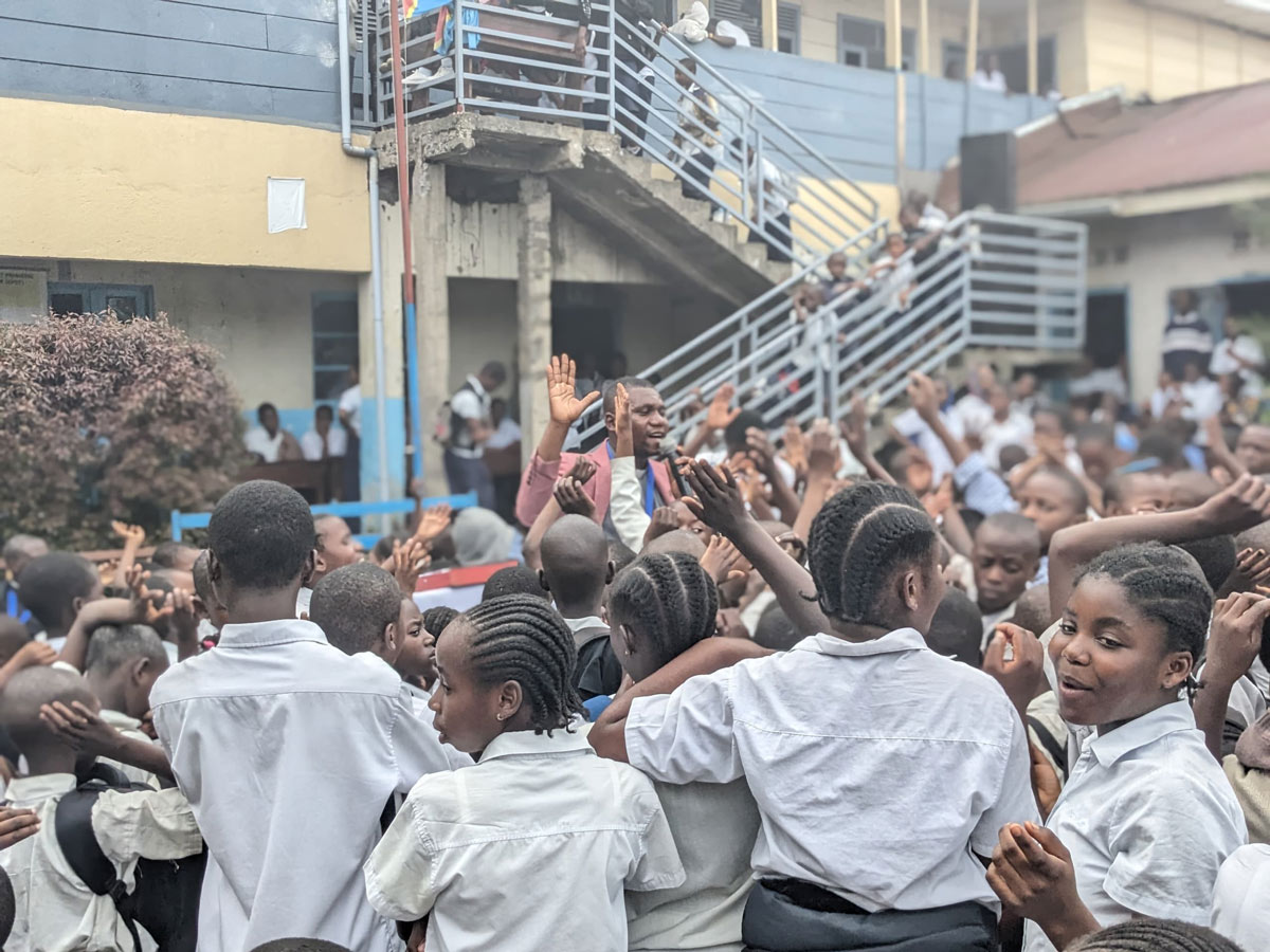 DRC: crowd of happy school children listening to speaker