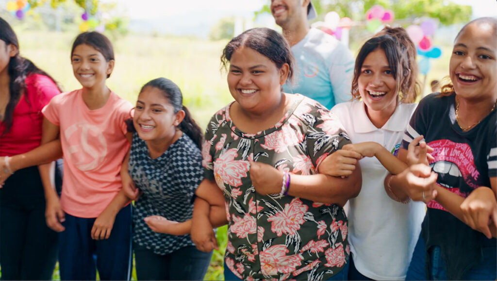 group of Honduran girls smiling arm in arm outdoors