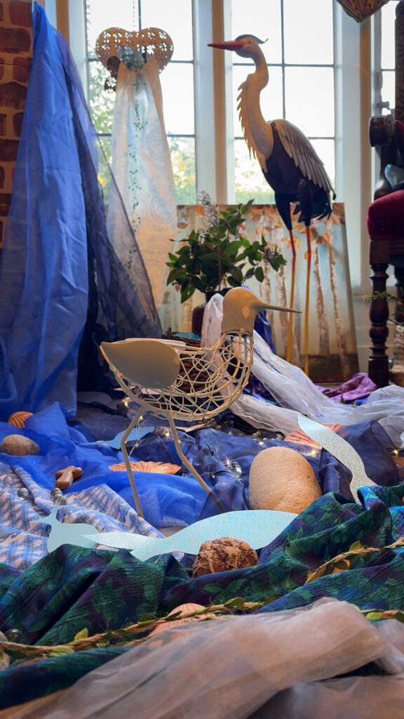 model heron and wader on fabric representing estuary shore