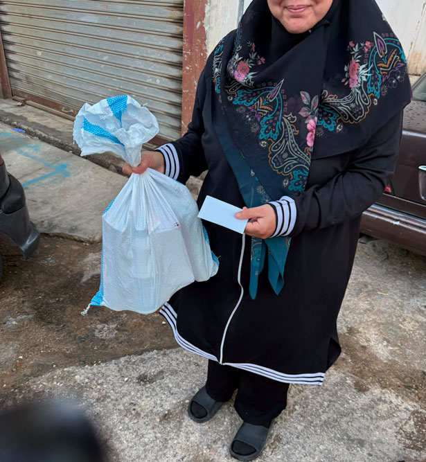 woman with emergency food pack and cash gift