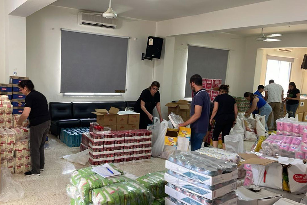 room with piles of supplies and people sorting