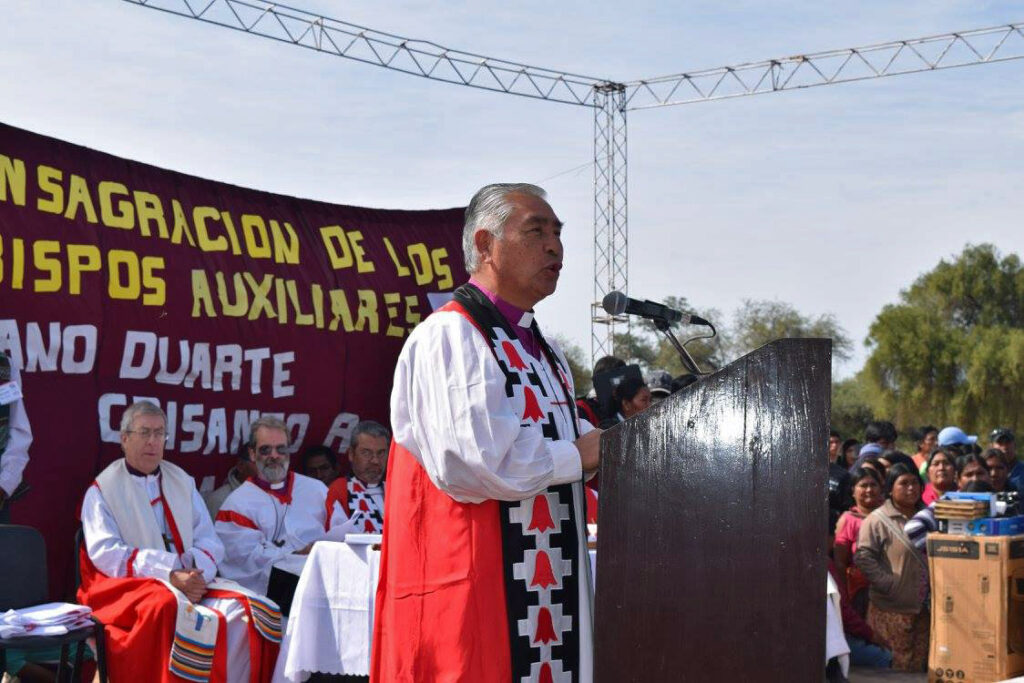 Bishop Abelino in formal bishop's robes speaking at open air event