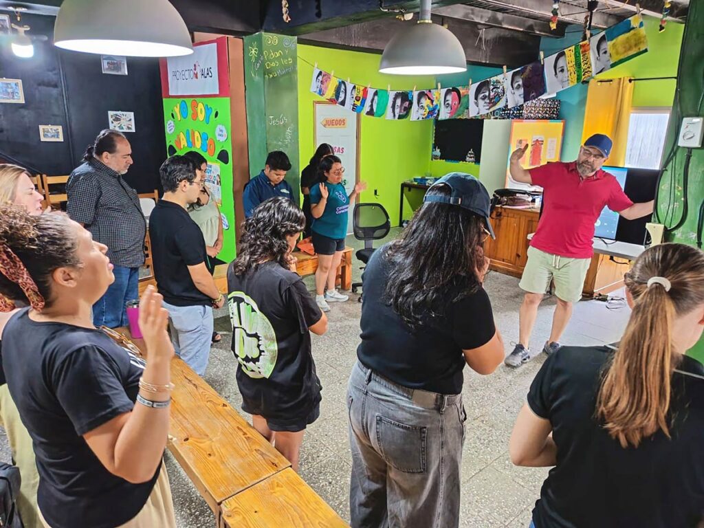Members of the network pray together in a room full of art