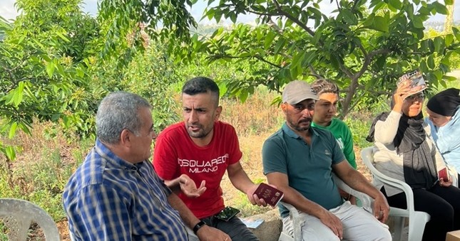 Lebanese man shrugs as he shares his story with another