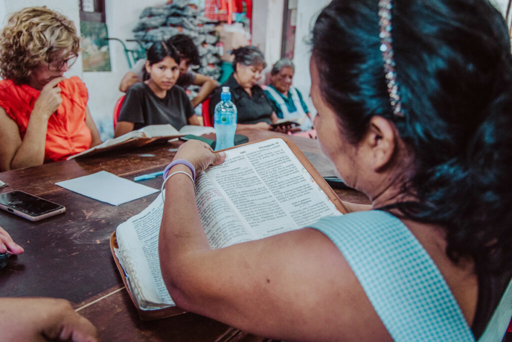 Looking over Jenny's shoulder into an open Bible during a Bible study session